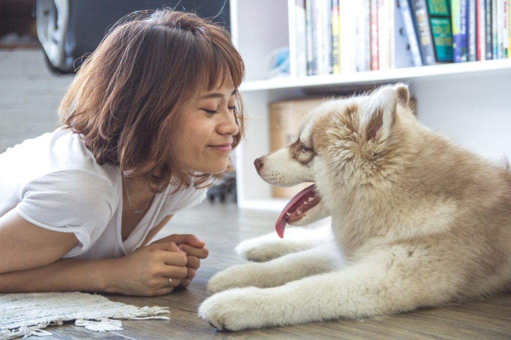 Decorative photo of a woman and her dog smiling on the floor